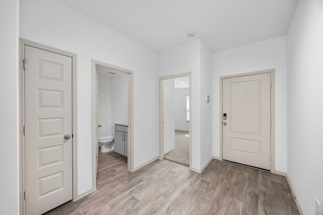 entryway featuring baseboards and light wood-style flooring