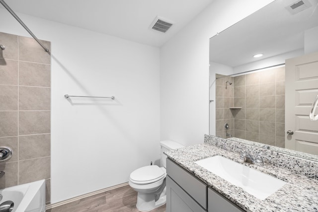 bathroom featuring wood finished floors, visible vents, toilet, and shower / washtub combination