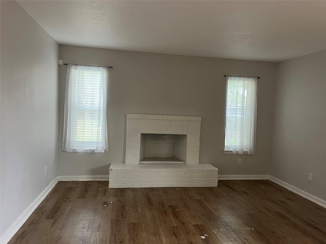 10555 Turtlewood Ct Unit 1008, Houston, TX 77072 - unfurnished living room with dark wood finished floors, baseboards, and plenty of natural light