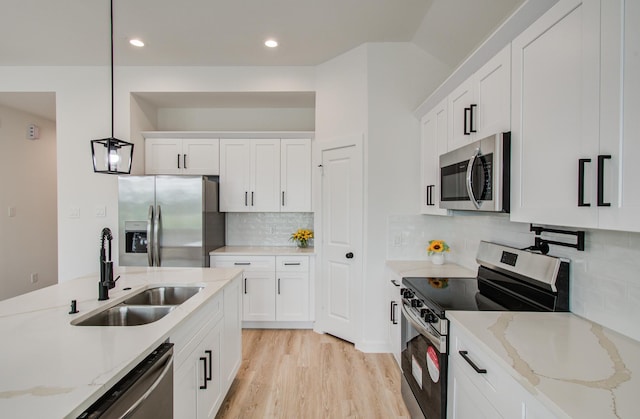1920 1st St, Hempstead, TX 77445 - kitchen with white cabinets, decorative light fixtures, appliances with stainless steel finishes, and a sink