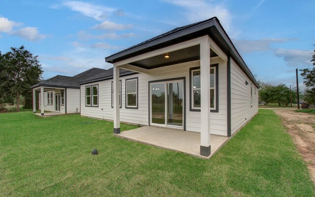 1920 1st St, Hempstead, TX 77445 - rear view of property featuring a lawn and a patio
