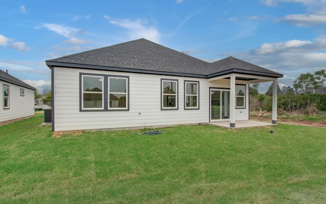 1920 1st St, Hempstead, TX 77445 - rear view of property with a patio area, roof with shingles, central AC, and a lawn