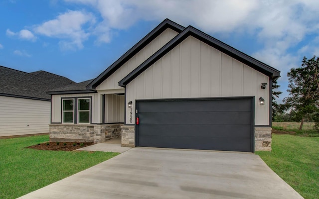 1920 1st St, Hempstead, TX 77445 - view of front of house featuring a garage, a front yard, stone siding, and concrete driveway