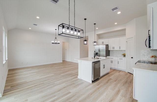 1920 1st St, Hempstead, TX 77445 - kitchen featuring stainless steel appliances, visible vents, light wood-style floors, backsplash, and light countertops