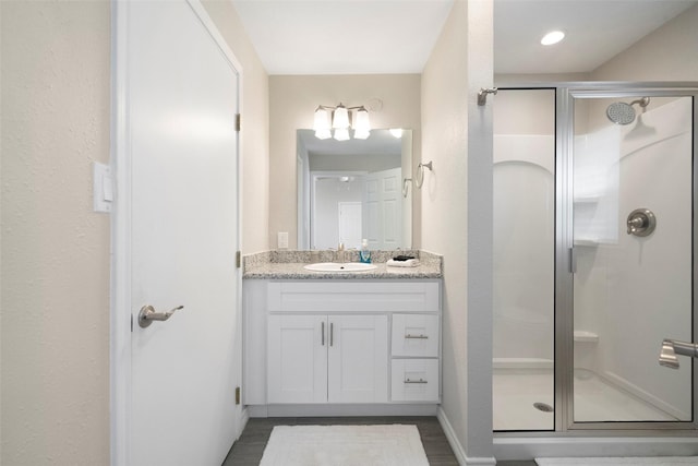 full bath featuring a shower stall, vanity, and wood finished floors