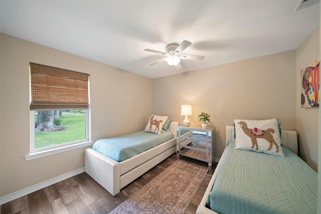 bedroom featuring dark wood-type flooring, visible vents, baseboards, and ceiling fan