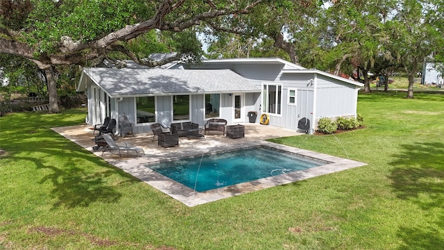 rear view of house with a lawn, a shingled roof, an outdoor pool, and a patio