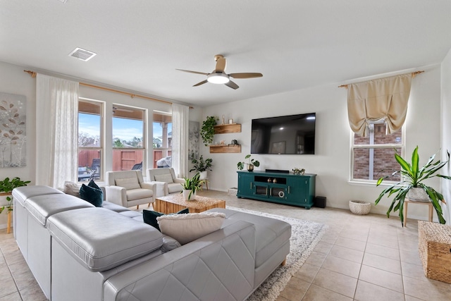 living room with light tile patterned flooring, a wealth of natural light, and a ceiling fan