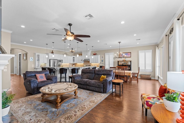 living room with arched walkways, dark wood finished floors, visible vents, recessed lighting, and ceiling fan with notable chandelier