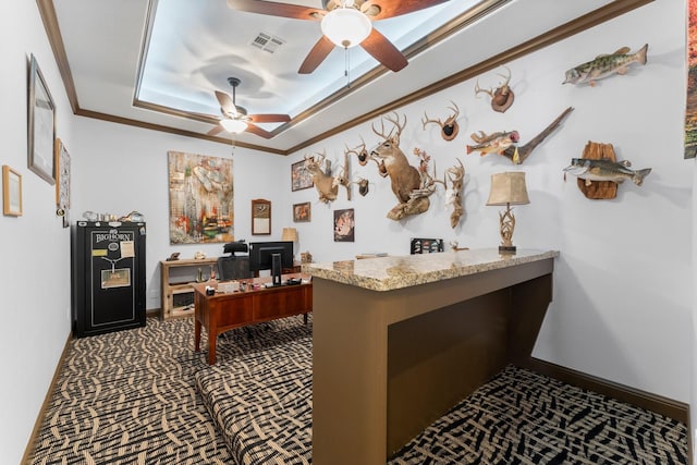 office with a ceiling fan, crown molding, a raised ceiling, dark colored carpet, and visible vents