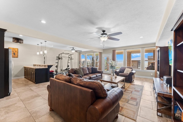 living area featuring baseboards, recessed lighting, and a healthy amount of sunlight