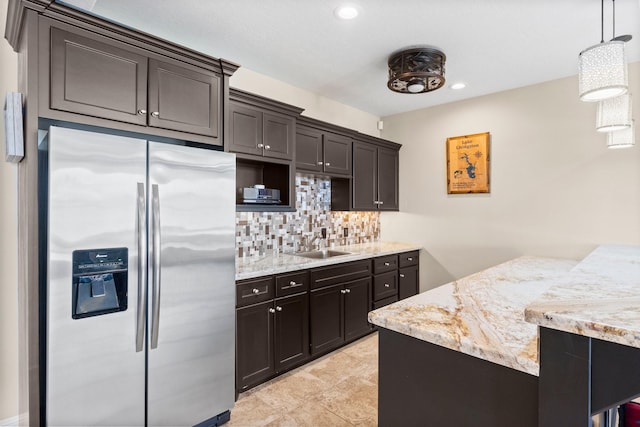 kitchen featuring tasteful backsplash, a sink, stainless steel fridge with ice dispenser, dark brown cabinetry, and recessed lighting