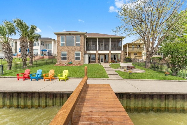 back of property featuring brick siding, a sunroom, a patio, and an outdoor fire pit