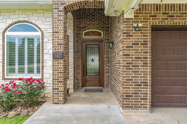view of exterior entry featuring brick siding