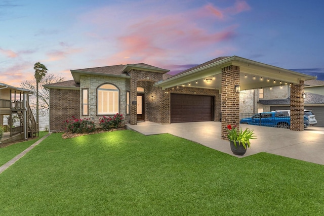 view of front of property with a garage, a lawn, brick siding, and concrete driveway
