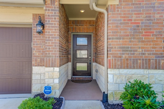 view of exterior entry with brick siding