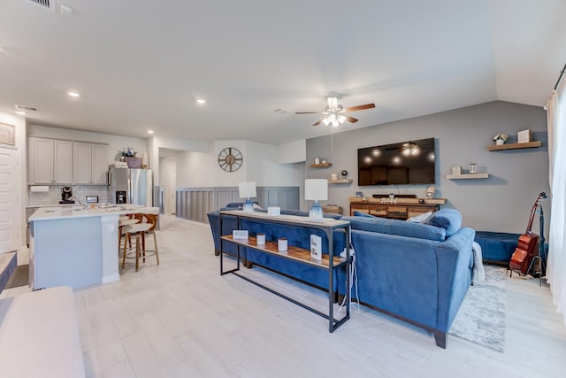 living room featuring ceiling fan, recessed lighting, and light wood-type flooring