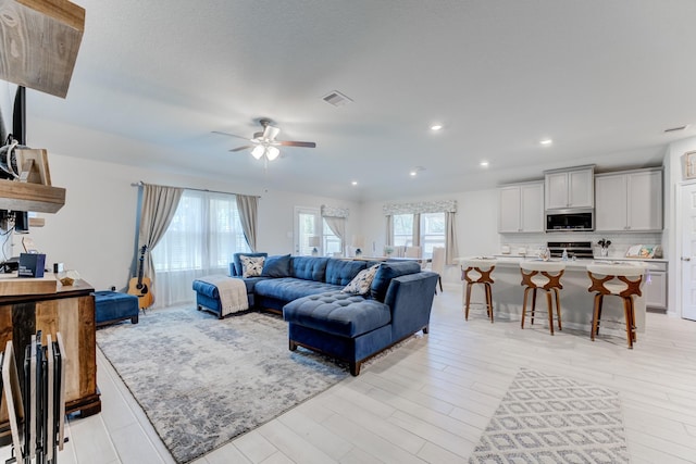 living area with recessed lighting, light wood-style floors, visible vents, and ceiling fan