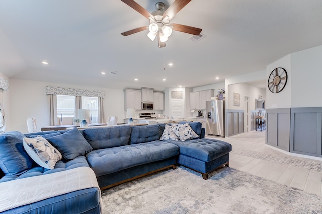living room featuring recessed lighting, light wood-style flooring, visible vents, and ceiling fan