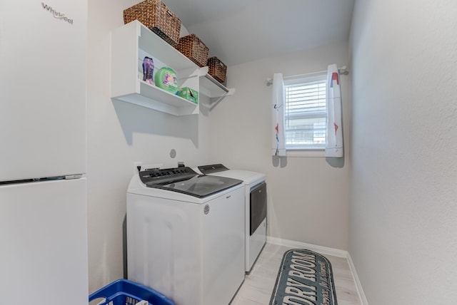 laundry room with baseboards, washer and clothes dryer, and laundry area