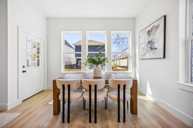 dining area featuring baseboards and light wood finished floors