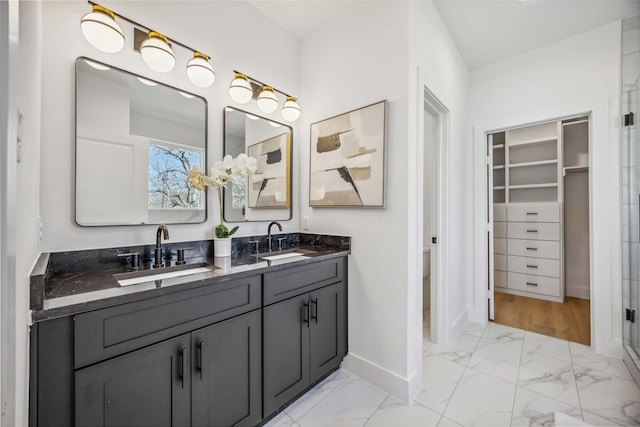 full bathroom with baseboards, a sink, and marble finish floor