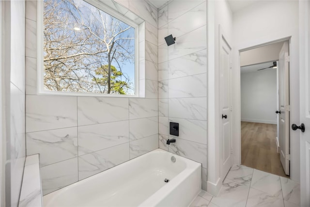 bathroom with shower / washtub combination, baseboards, and marble finish floor