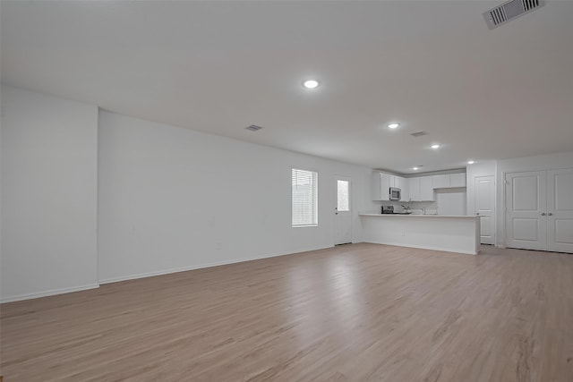 24119 Maple Turn Ln, Hockley, TX 77447 - unfurnished living room featuring recessed lighting, light wood-style floors, and visible vents