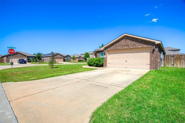 ranch-style home featuring a front lawn, driveway, fence, brick siding, and a garage