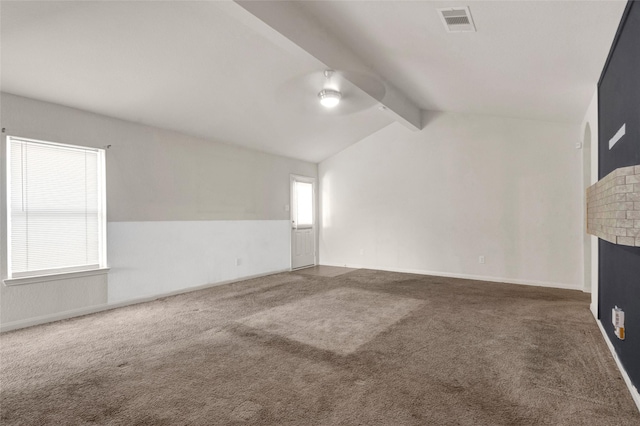 unfurnished living room featuring vaulted ceiling with beams, visible vents, baseboards, a brick fireplace, and carpet floors