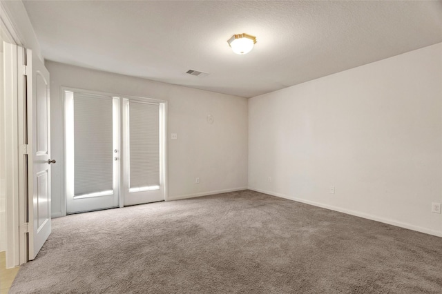 unfurnished room featuring carpet floors, visible vents, and baseboards