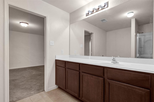full bathroom featuring tile patterned floors, baseboards, visible vents, a shower, and vanity