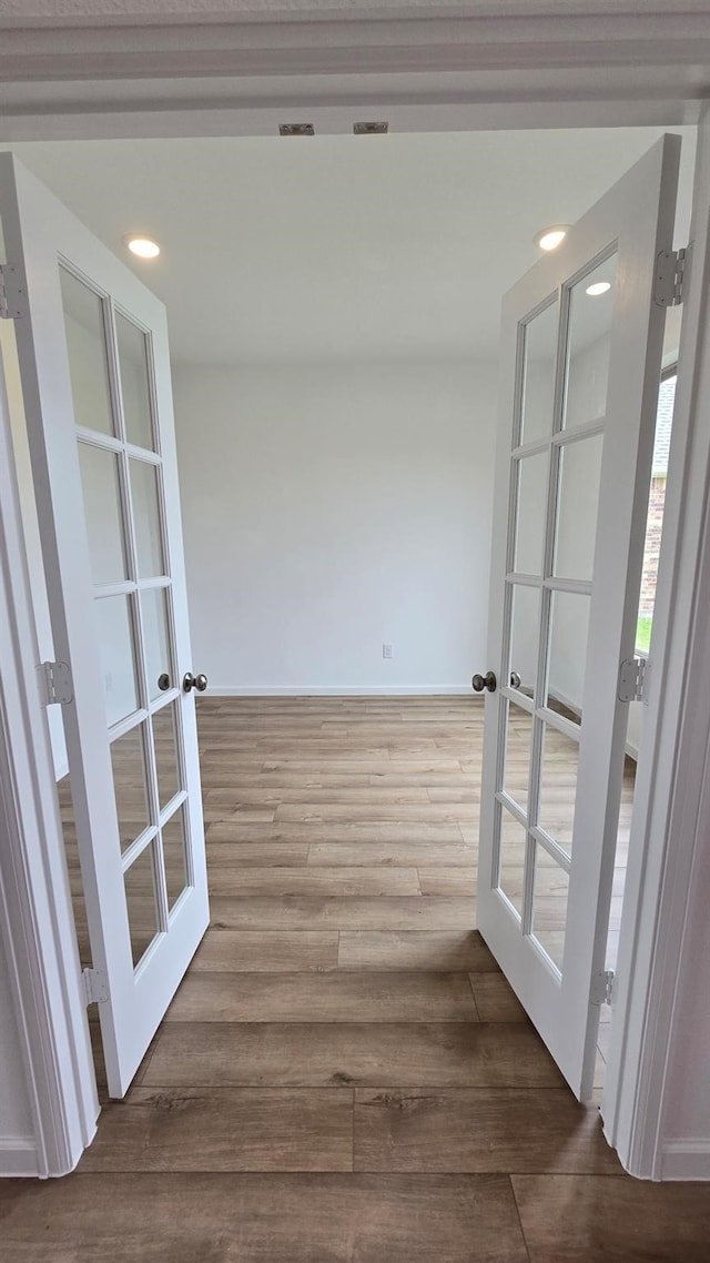 hall with french doors, wood finished floors, and recessed lighting