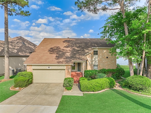 11831 Thoreau Dr, Montgomery, TX 77356 - view of front of house with central AC unit, brick siding, a front yard, and concrete driveway