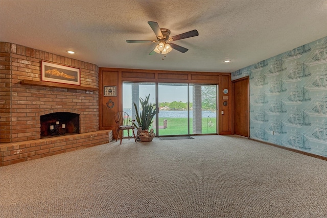 11831 Thoreau Dr, Montgomery, TX 77356 - carpeted living room featuring a fireplace, baseboards, a textured ceiling, and ceiling fan