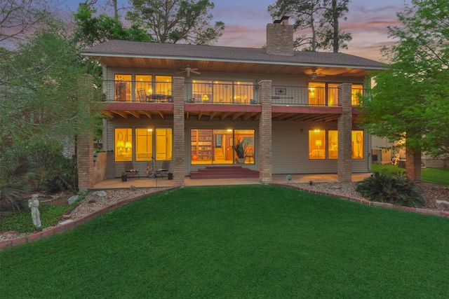11831 Thoreau Dr, Montgomery, TX 77356 - back of house at dusk featuring a chimney, a balcony, and a yard
