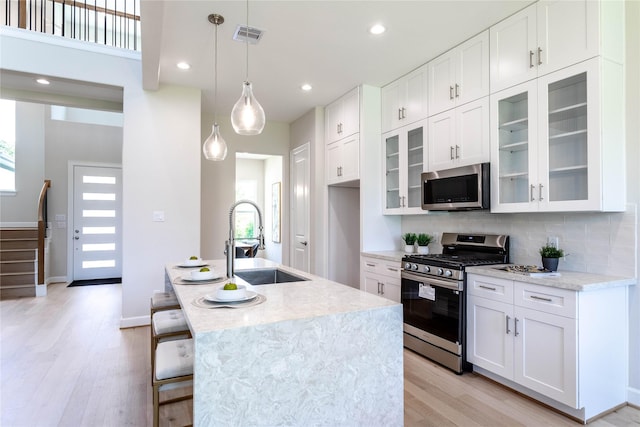 1114 Niagara St, Houston, TX 77051 - kitchen with light wood finished floors, stainless steel appliances, a sink, and a wealth of natural light