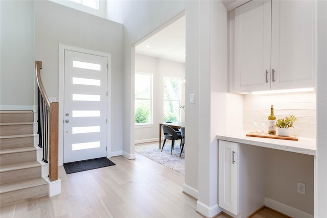 1114 Niagara St, Houston, TX 77051 - entryway with baseboards, a dry bar, stairs, and light wood finished floors