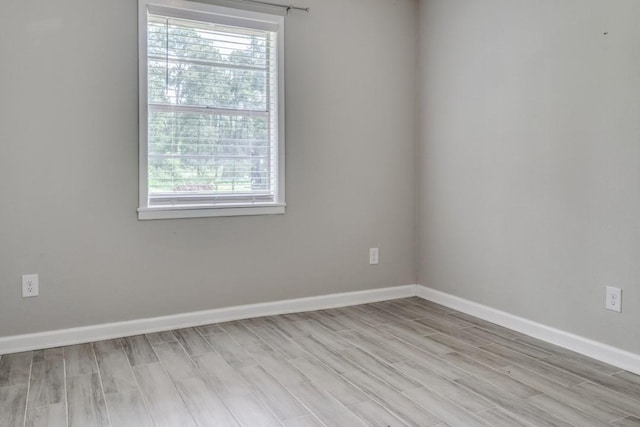 empty room with baseboards and light wood-style floors