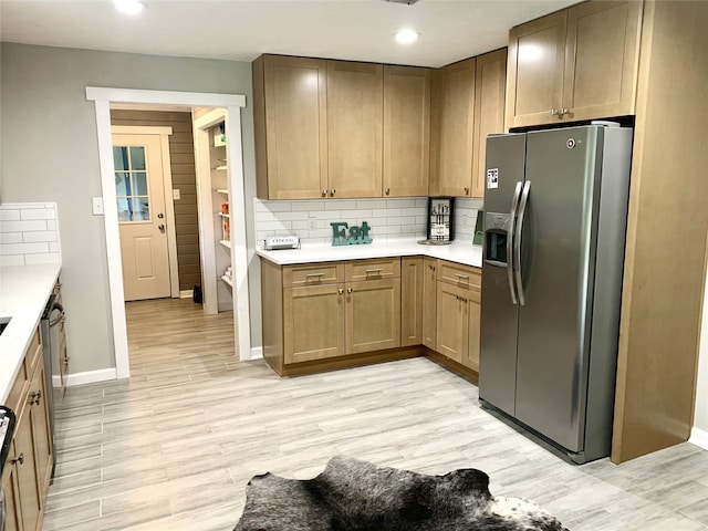 kitchen featuring stainless steel fridge, light wood-type flooring, baseboards, decorative backsplash, and light countertops