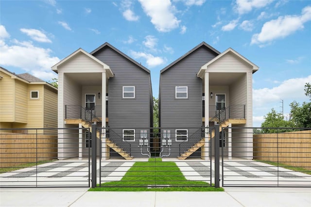 view of front of home featuring a gate, stairs, and a fenced front yard