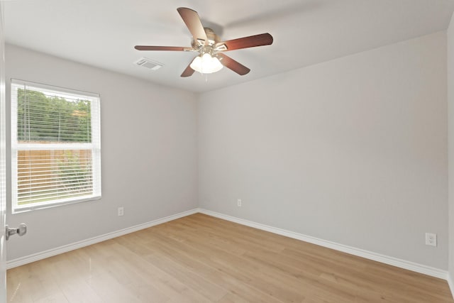 unfurnished room featuring light wood-style floors, baseboards, ceiling fan, and visible vents
