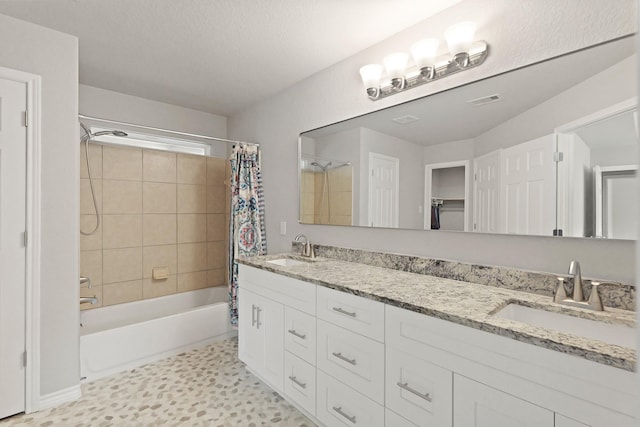 bathroom featuring a sink, visible vents, double vanity, and shower / bath combination with curtain
