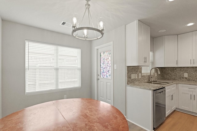 kitchen with white cabinets, a chandelier, a sink, and dishwasher