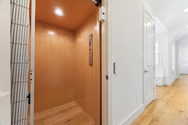 hall with wood-type flooring, elevator, and recessed lighting