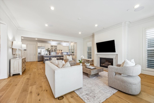 living area featuring recessed lighting and ornamental molding