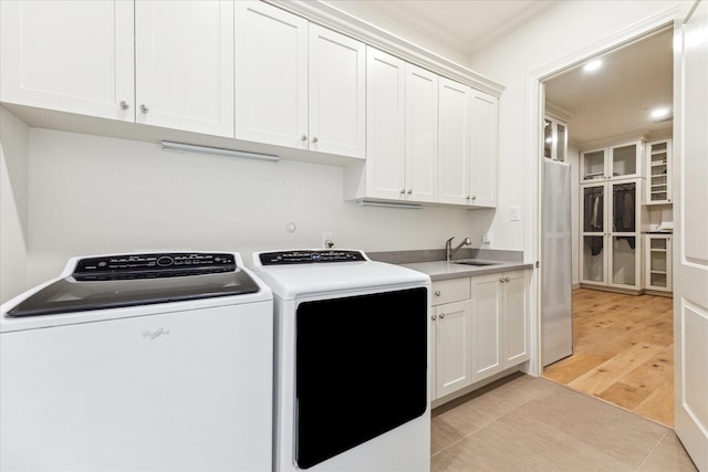 laundry area with recessed lighting, ornamental molding, a sink, separate washer and dryer, and cabinet space
