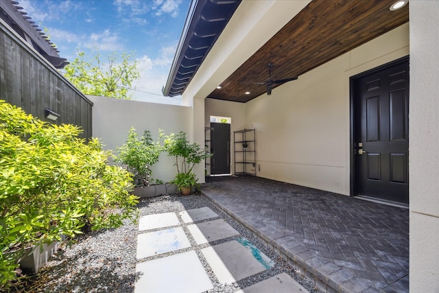 doorway to property with stucco siding, a patio, and ceiling fan