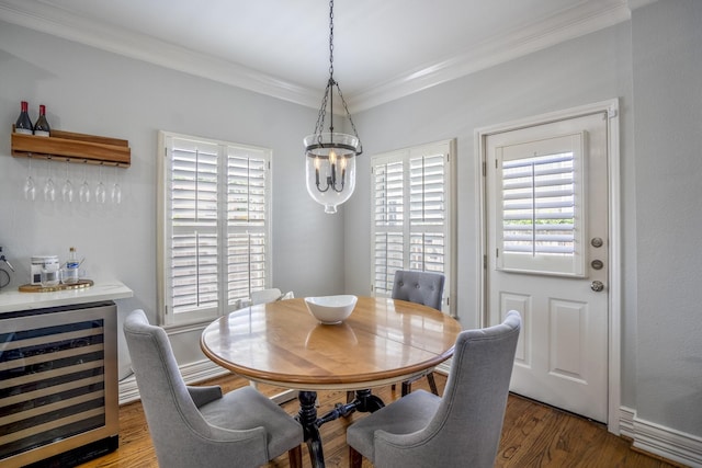 dining area with a wealth of natural light, ornamental molding, beverage cooler, and a notable chandelier