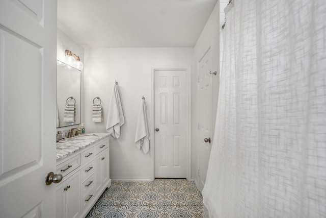 full bathroom featuring vanity, baseboards, and tile patterned flooring